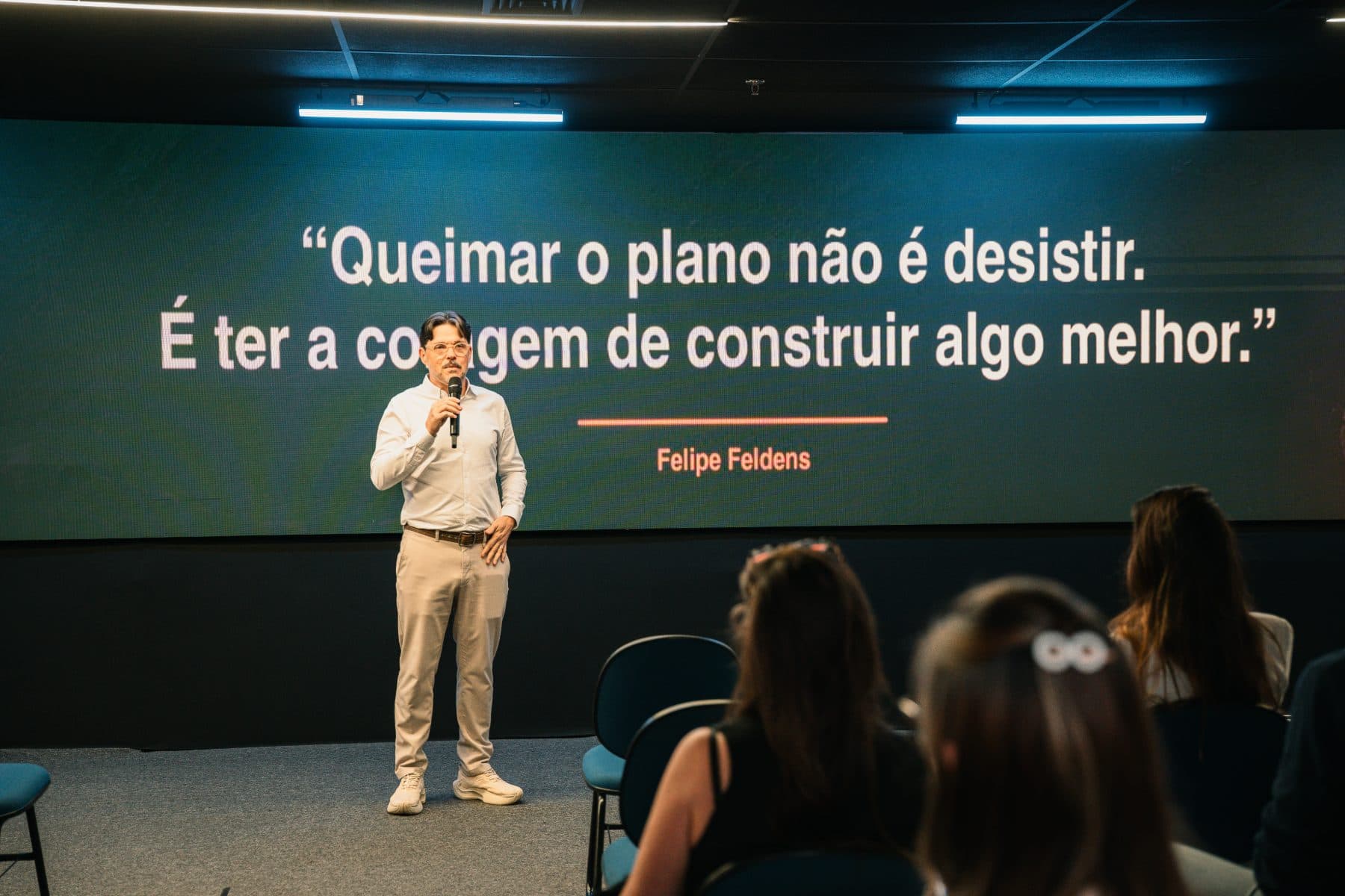 Telão verde com a frase: Queimar o plano não é desistir. É ter a coragem de construir algo melhor.